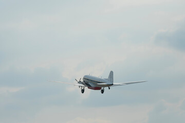 Military plane flying through the sky and clouds on nature background
