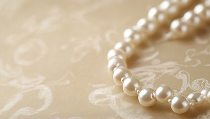 Delicate pearl necklace on a soft beige fabric