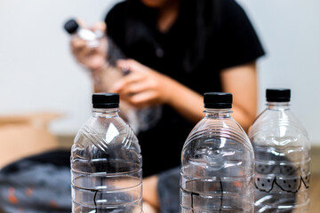 Selective Focus Of Plastic Water Bottles Against Person In Creative Recycling Activity Background