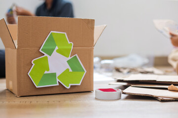 Cardboard Box With Recycling Symbol On Wooden Floor
