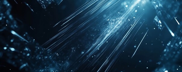 Abstract blue light streaks and particles on dark background.