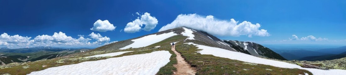 Obraz premium Panoramic view of a mountain peak with snow and a hiking trail