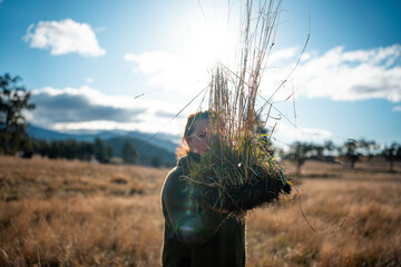 woman in agriculture looking at a soil sample. girl on a farm looking at plant roots