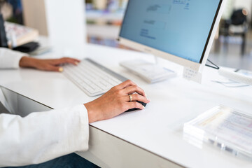 Optician working on computer using mouse and keyboard