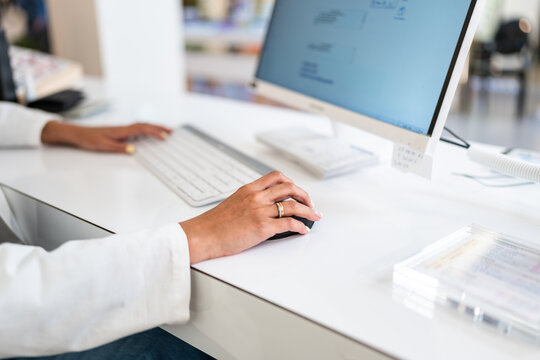 Optician working on computer using mouse and keyboard