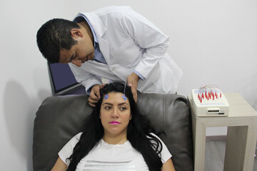 Electroencephalogram, a neurological study of an adult Latina woman with wires on her head to...