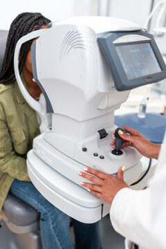 Optician examining patient eyesight with autorefractor