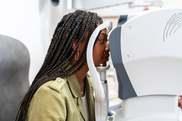 Patient using a phoropter for eye exam during a visit