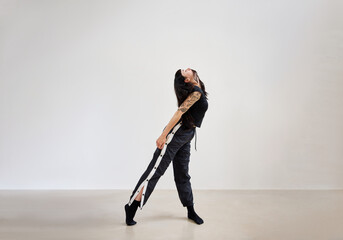 Dancer performs elegant stretch in modern studio setting during 