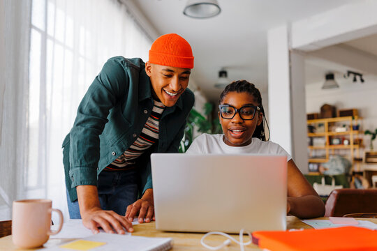Two happy roommates studying together on apartment