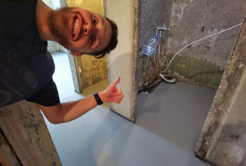 Smiling man giving thumbs up near fresh concrete