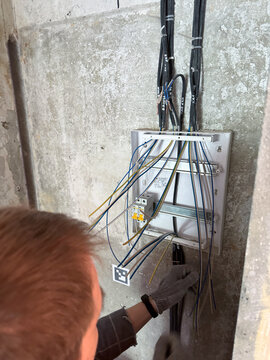 Electrician installing wires in distribution panel