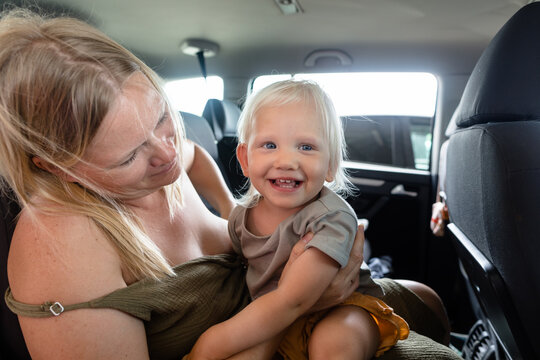 Laughing baby on mother's lap in a car