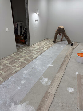 Worker installing laminate flooring at home