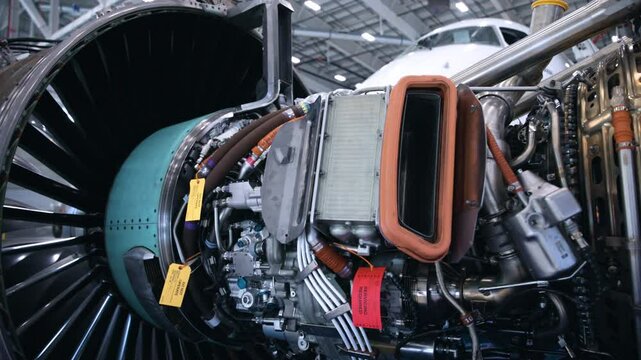Engineers Working on a jet engine in an airplane hangar
