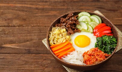 Bibimbap is a Korean dish in the form of a bowl of white rice topped with side dishes of vegetables, beef, eggs and spicy gochujang sauce.