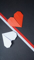 Red and white heart shaped origami with red and white Indonesia flag color ribbon isolated on black background