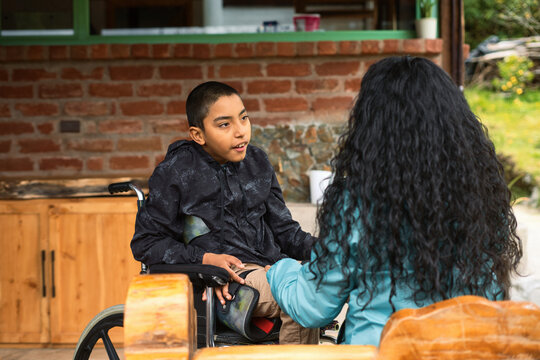 Disabled child talking with therapist outdoors - Powered by Adobe