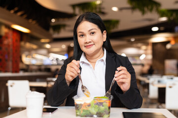 Businesswoman eating salad