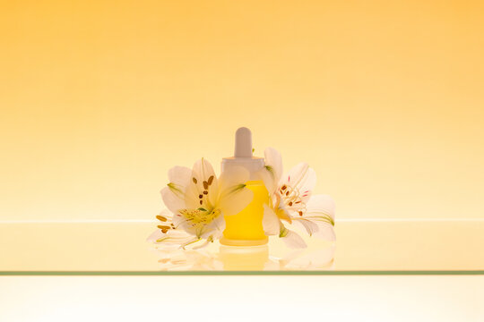 Serum bottle with orange gradient background and flowers