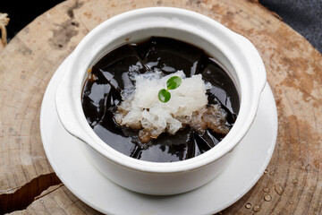 White soup bowl of Tremella Guiling placed on a camphorwood chopping board