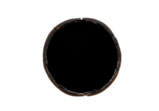 A round hole burnt through black paper isolated on transparent background
