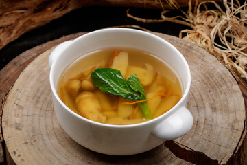Cordyceps flower and pine mushroom soup in a white porcelain bowl