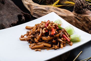 Rectangular porcelain plate with cashew nuts, peppers and king oyster mushrooms on a black background