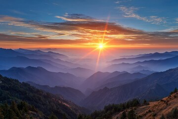 Obraz premium Vibrant sunrise over layered mountains with soft mist and colorful sky above them
