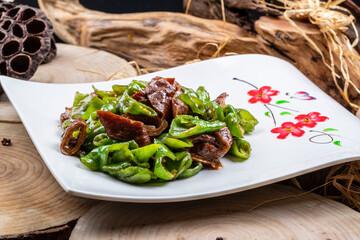 Spicy peppers and pork intestines are placed on a camphorwood chopping board