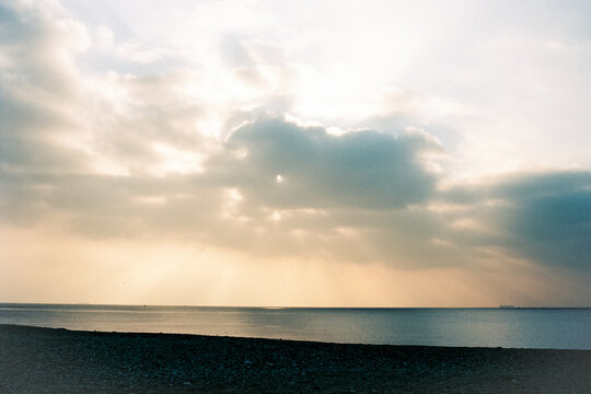 Sunrise Over Calm Waters at Coastal Location With Cloudy Sky