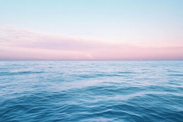 Obraz premium Peaceful ocean sunrise. Pastel pink and blue sky meets a calm sea. Horizon line is clear