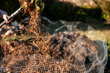 turning a compost pile in a community garden. compost full of microorganisms. sustainable...