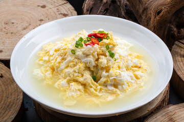 Spring water scrambled eggs in a white porcelain plate