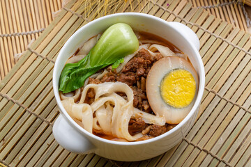 Rapeseed, egg and diced pork noodles in a white porcelain bowl