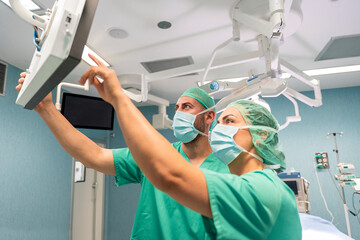 Surgeons adjusting surgical lights in operating room