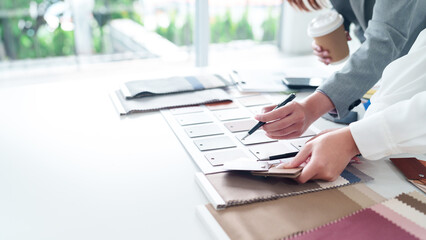 Interior Design Selection Hands On Meeting For Asian Women Discussing Color And Material Samples For Home Renovation Project With Pen And Coffee Cup