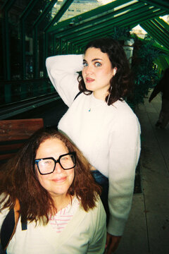 Mother and adult daughter  posing playfully in a park 
