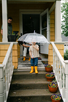 little boy getting down front door steps in the rain 
