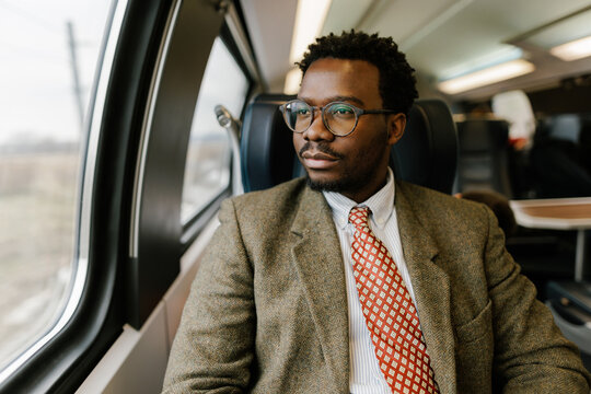 Portrait of businessman commuting with train looking through window