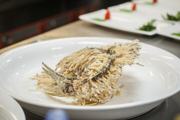 Semi-finished products and finished products of the famous dish Golden Lionfish being prepared in the kitchen