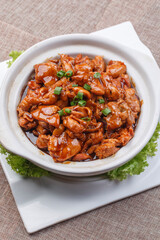 Stir-fried melon with clam meat in a white round porcelain plate