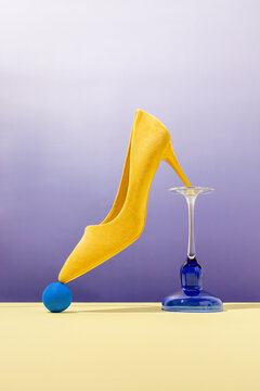 Yellow high-heel balancing on modern objects with bold colors 