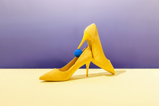 Yellow suede high heels with a vibrant purple background