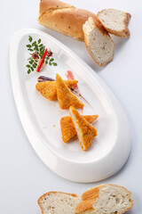 Deep-fried fresh shrimp cakes cut into pieces on a white porcelain plate