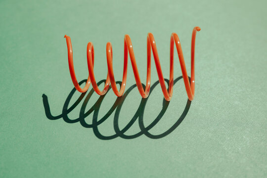 Colorful spiral toy casting shadows on a green surface