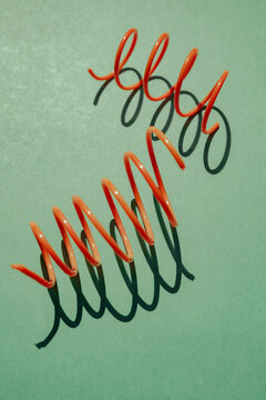 Colorful spirals create playful shadows on a green surface