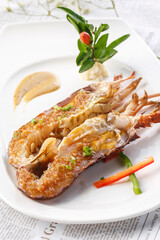 Pan-fried Australian lobster with garlic sauce on a white porcelain plate