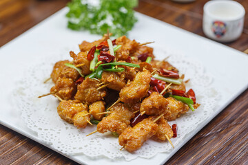 Crispy toothpick meat in a square white porcelain plate