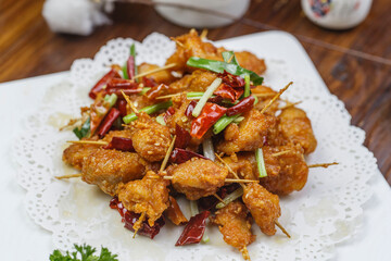 Crispy toothpick meat in a square white porcelain plate